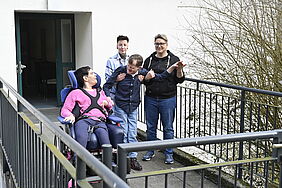 Eine Gruppe Personen auf einer Terrasse.