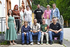 Eine Gruppe von Erwachsenen steht auf Treppenstufen.