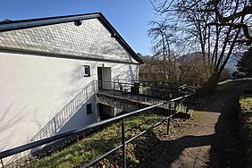 Seite eines Hauses mit einer Terrasse. 