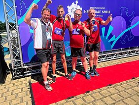 [Translate to Leichte Sprache:] Sportler der Stiftung Scheuern jubeln über ihre Medaillen bei den Special Olympics Nationale Spiele 2022 in Berlin.