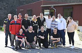 Sportlerinnen und Sportler sowie Trainer und Betreuer stehen für ein Gruppenfoto zusammen.