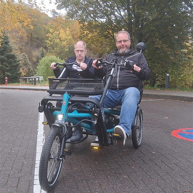 Zwei Männer auf einem Fahrrad für zwei Personen.